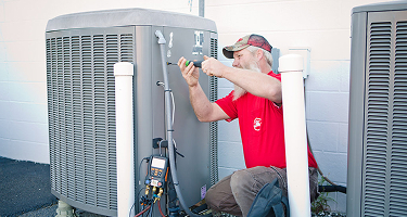 Comfort Control employee working on an outside HVAC unit